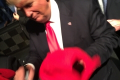 Trump signing his hat...